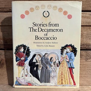 May include: A vintage hardcover book titled "Stories from The Decameron of Boccaccio." The cover features illustrations of people in medieval attire, with text and decorative sun-like designs. The book is set against a wooden background.