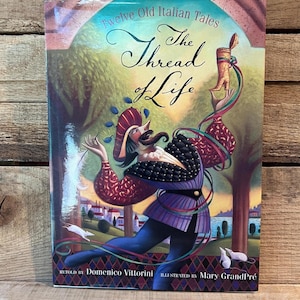 May include: A book titled "Twelve Old Italian Tales" with the title "The Thread of Life" in elegant script. The cover features a colorful illustration of a figure in a theatrical costume, with a landscape background and the text "Retold by Domenico Vittorini, Illustrated by Mary GrandPré."