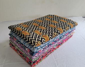 May include: A stack of folded fabric with various patterns. The top fabric features a black and white zigzag design with orange tiger illustrations. Other fabrics display floral and geometric patterns in shades of blue, green, purple, and red.