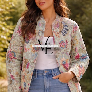 May include: A light green quilted jacket featuring a vibrant floral pattern in shades of pink, orange, and blue. The jacket has long sleeves, a round neckline, and a front button closure. The text VINAYAKAM EXPORTS is printed across the center.