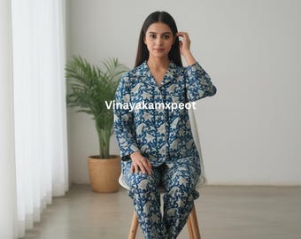 May include: A blue and white floral print pajama set. The long-sleeved top has a collared neckline and button-down front. The matching pants are full-length. The text "Vinayakamxpeot" is visible on the image.