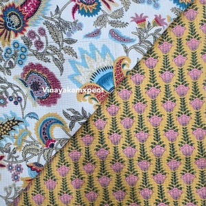 May include: A split-screen image showcases two distinct fabric patterns. One side features a white background with a colorful floral design in shades of blue, pink, and gold. The other side displays a yellow background with a repeating pink floral pattern.