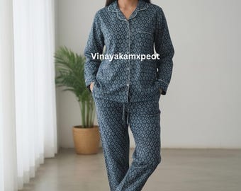 May include: A two-piece pajama set in a blue diamond pattern with white trim. The long-sleeved top has a button-down front and a notched collar. The pants have a drawstring waist. The text "Vinayakamxpeot" is visible on the shirt.