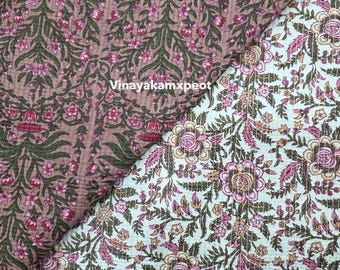 Può includere: Due campioni di tessuto con motivi floreali. Uno è di colore rosa antico con foglie verdi e fiori rosa. L'altro è verde chiaro con fiori rosa e beige e foglie verdi. Il testo "Vinayakamxpeot" è visibile.
