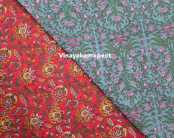 Può includere: Due campioni di tessuto con motivi floreali. Uno è rosso con fiori gialli e bianchi, l'altro è verde acqua con fiori rosa. Il testo "Vinayakamxpeot" è visibile sul tessuto.