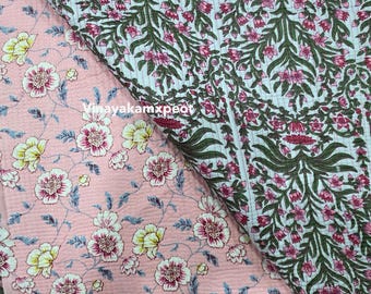 Può includere: Due tessuti a fantasia floreale. Uno è rosa chiaro con fiori bianchi e gialli, l'altro è bianco con foglie verdi e fiori rosa. I tessuti sono piegati l'uno sull'altro.