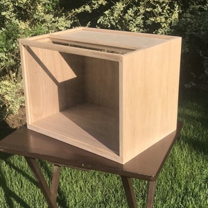 May include: A light wood box with a clear glass top. The box is empty and has a simple design.