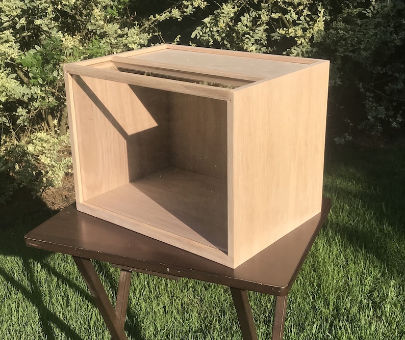 May include: A light wood box with a clear glass top. The box is empty and has a simple design.