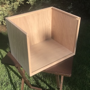 May include: A light wood box with a rectangular shape. The box is open and empty, showing the inside of the box.