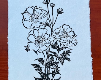 May include: A rectangular piece of white paper with deckled edges featuring a black ink block print of a floral arrangement. The illustration depicts three blooming poppy flowers with detailed petals, serrated leaves, and several small flower buds.