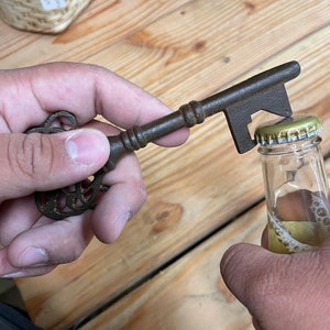 Abridor de garrafas de ferro fundido Bordello com acabamento envelhecido e ferrugem natural