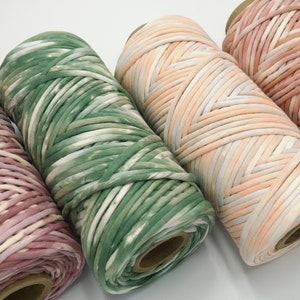May include: Four spools of colourful yarn, each with a different tie-dye pattern. The yarn is made of cotton and is perfect for crocheting or knitting.