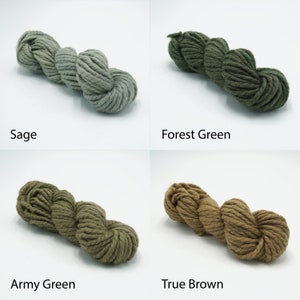 May include: Four skeins of yarn in different shades of green and brown. The yarn is a chunky weight and is made of natural fibers. The colors are Sage, Forest Green, Army Green, and True Brown.