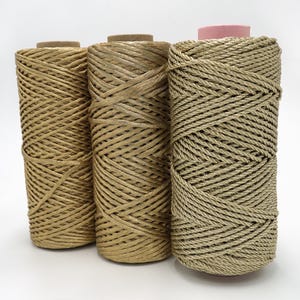 May include: Three spools of gold metallic cord, each with a different weave pattern. The cord is wound around cardboard spools.