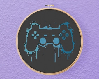 Schema punto croce per videogiocatore con graffiti e ombre sul controller PlayStation (download PDF)