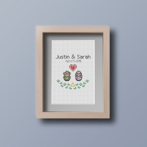 May include: A framed cross-stitch design featuring pixelated characters from the Legend of Zelda video game series. The design includes Link and Princess Zelda, a heart, and the Triforce symbol. The text "Justin & Sarah April 7, 2018" is above the characters.