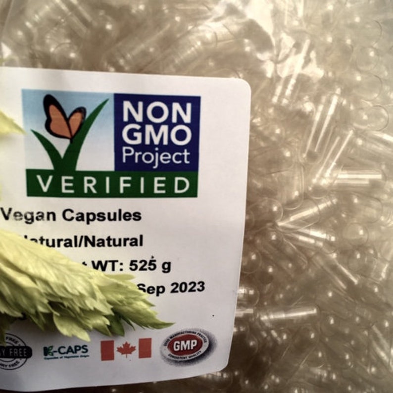 Puede incluir: Una bolsa de c&aacute;psulas veganas transparentes y vac&iacute;as de tama&ntilde;o 0. La bolsa est&aacute; etiquetada con el logotipo del proyecto Non-GMO Project Verified, y el texto "Vegan Capsules", "Natural/Natural", "WT: 525 g" y "Sep 2023".
