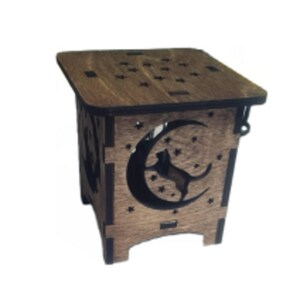 May include: A wooden box with a cutout design of a cat sitting on a crescent moon. The box has a dark brown stain and is decorated with small stars.
