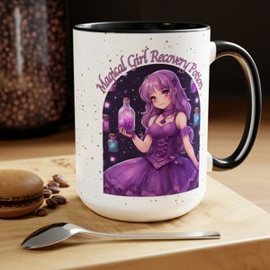 May include: White ceramic mug with a black rim and handle. The mug features a colorful illustration of a magical girl holding a bottle of potion with a starry sky background. The text "Magical Girl Recovery Potion" is printed in a black arch above the illustration.