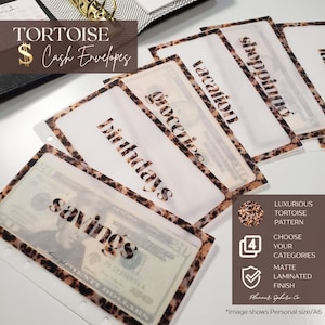 May include: A set of translucent cash envelopes featuring a brown and black tortoise shell pattern border. Each envelope is labeled with black text including savings, birthdays, groceries, vacation, and shopping, with some containing US currency.