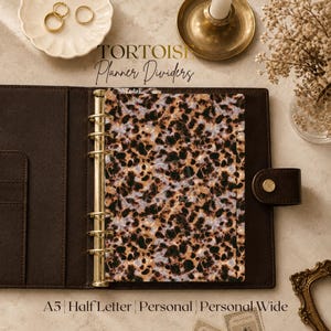 May include: A dark brown leather planner binder featuring a gold six-ring mechanism and a single planner divider with a brown, black, and cream tortoise shell pattern. The divider has a small tab at the top labeled with the word Today.