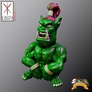 May include: A green and red figurine of a sitting orc with a large mouth and a red ponytail. The orc is wearing a white band around each wrist.