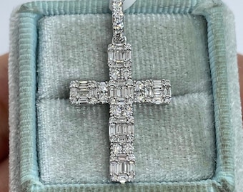 May include: A silver cross pendant with baguette-cut diamonds set in a pave setting. The pendant is in a light blue velvet box.