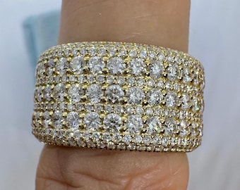 May include: A gold band ring with a wide, flat top set with multiple rows of small, round diamonds.