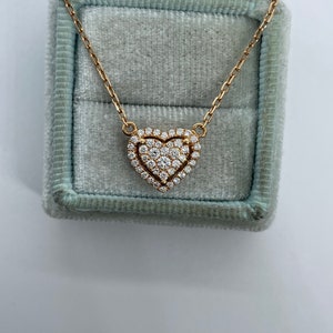 Puede incluir: Un collar de cadena de oro con un colgante en forma de coraz&oacute;n engastado con diamantes brillantes.