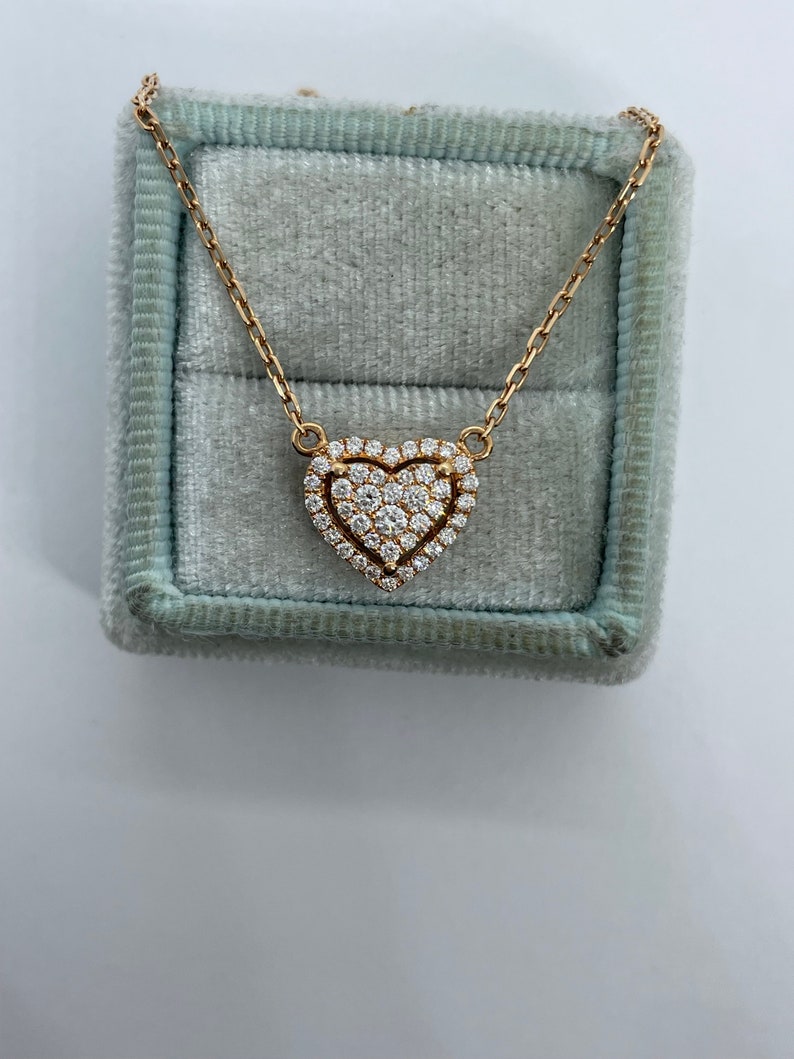Puede incluir: Un collar de cadena de oro con un colgante en forma de coraz&oacute;n engastado con diamantes brillantes.