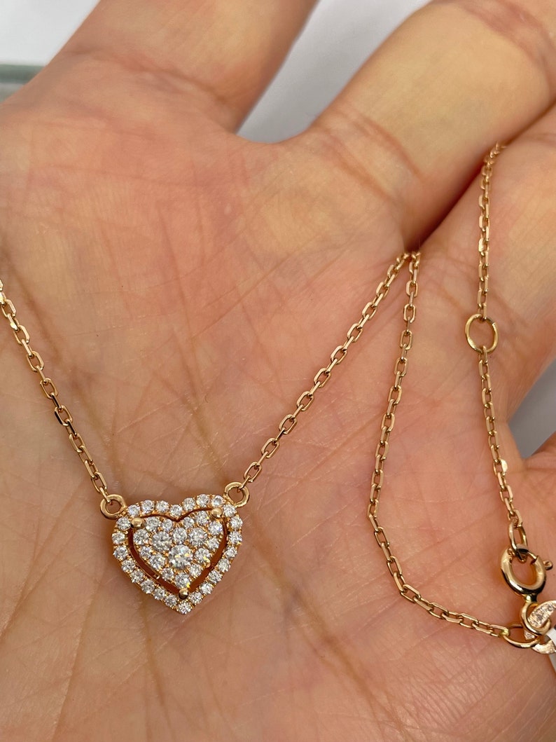 Puede incluir: Un collar de cadena de oro con un colgante en forma de coraz&oacute;n. El colgante est&aacute; cubierto de peque&ntilde;os diamantes.