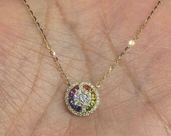 May include: A gold chain necklace with a round pendant featuring a rainbow of gemstones and a small diamond in the center.