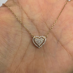 Puede incluir: Un delicado collar de oro con un colgante en forma de coraz&oacute;n. El colgante est&aacute; adornado con peque&ntilde;os diamantes brillantes.