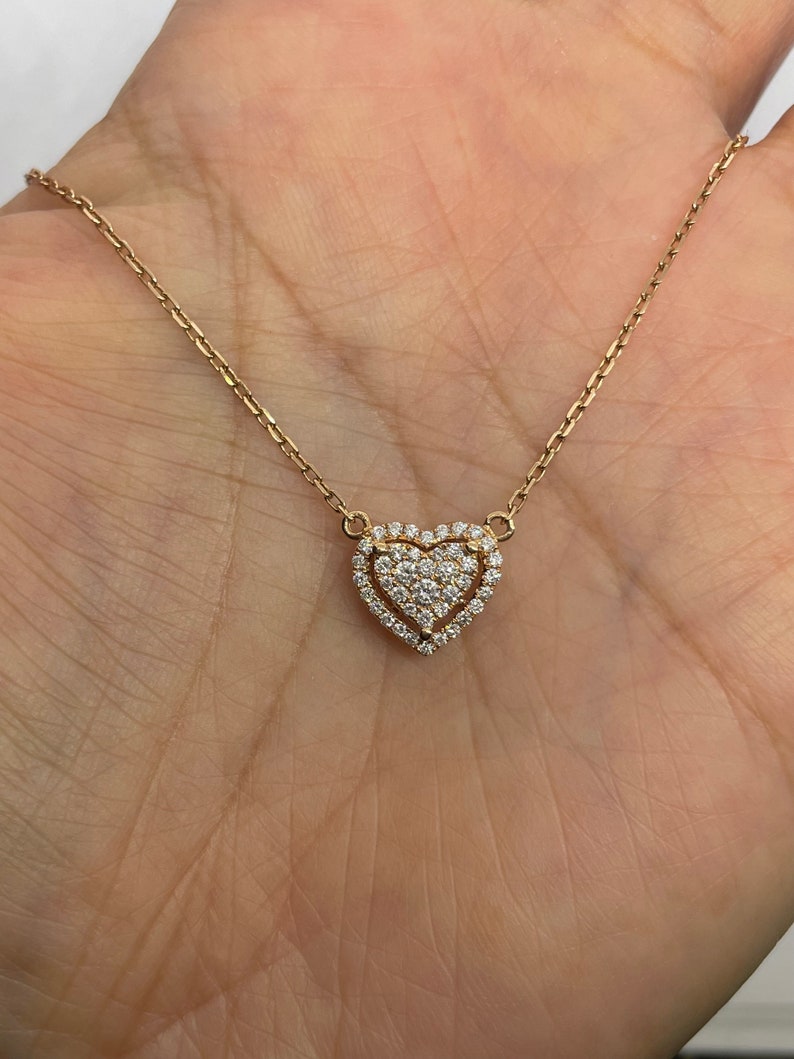 Puede incluir: Un delicado collar de oro con un colgante en forma de coraz&oacute;n. El colgante est&aacute; adornado con peque&ntilde;os diamantes brillantes.