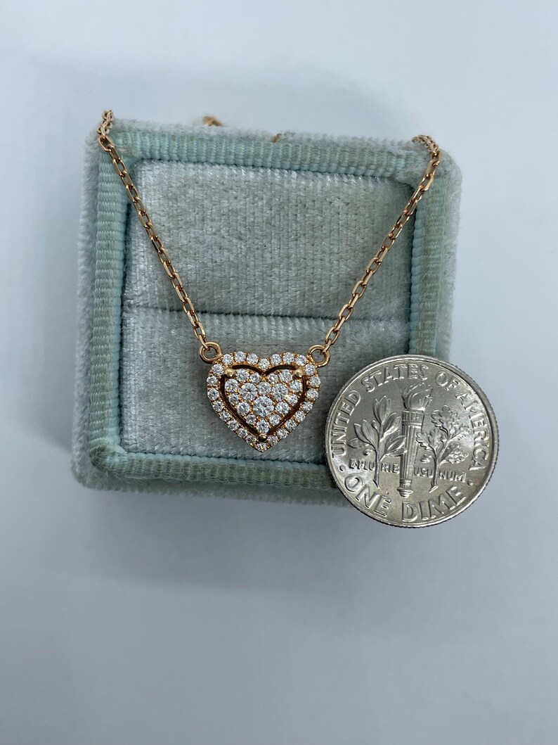 Puede incluir: Un collar de cadena de oro con un colgante en forma de coraz&oacute;n engastado con peque&ntilde;os diamantes. El colgante es aproximadamente del tama&ntilde;o de una moneda de diez c&eacute;ntimos.