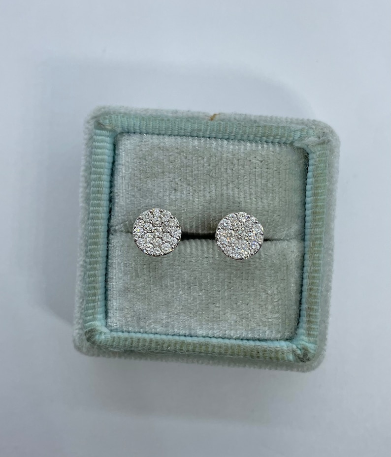 May include: A pair of round diamond stud earrings in a light blue velvet jewelry box.