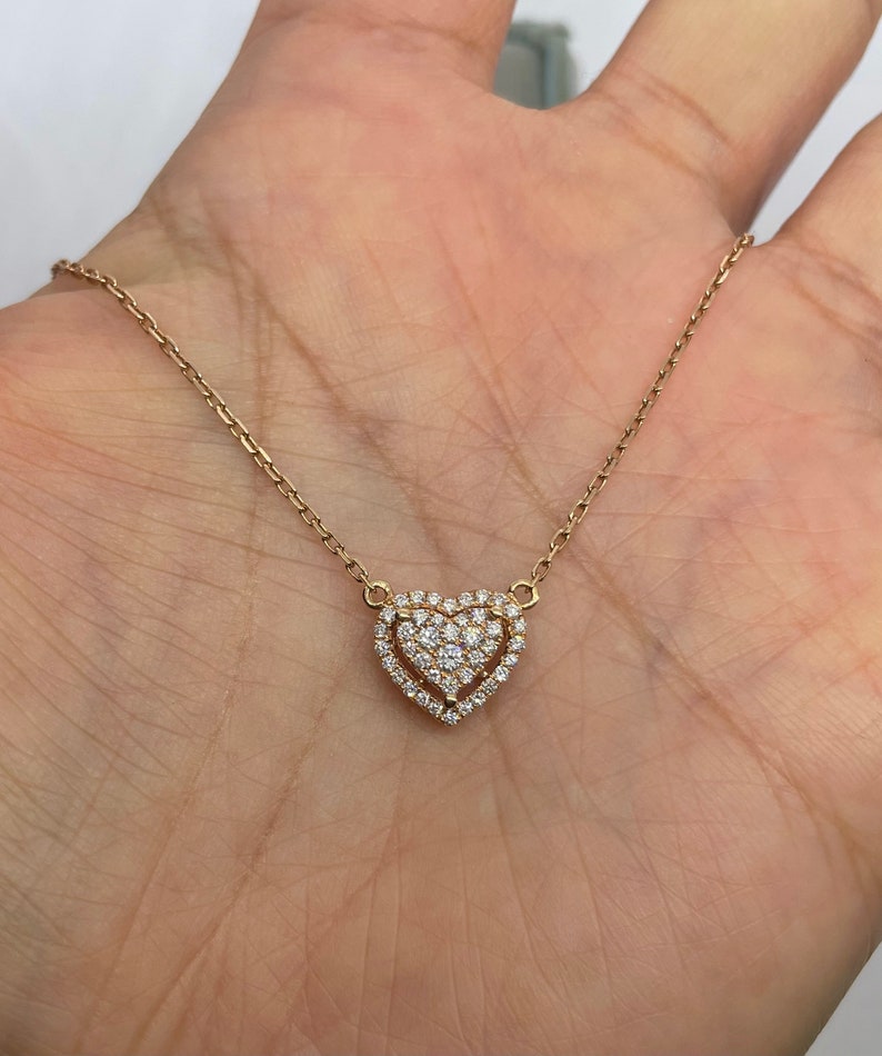 Puede incluir: Un collar de cadena de oro con un colgante en forma de coraz&oacute;n engastado con peque&ntilde;os diamantes.