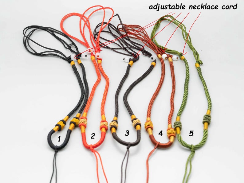 May include: Five adjustable necklace cords in black, red, brown, green, and orange. Each cord has a yellow and gold bead at the end. The cords are labeled 1 through 5.