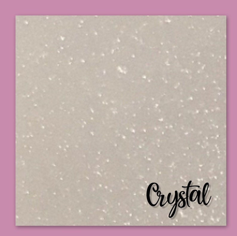 May include: A close-up of a white glitter background with the word "Crystal" written in black cursive.