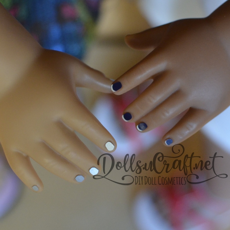 Puede incluir: Primer plano de dos manos con las u&ntilde;as pintadas. Una mano tiene esmalte de u&ntilde;as blanco y azul, la otra tiene esmalte de u&ntilde;as azul marino. La imagen incluye el texto "Dolls u Craft.net DIY Doll Cosmetics".