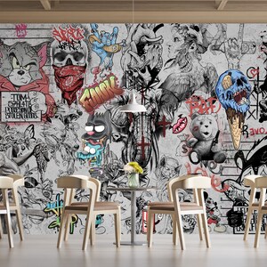 K&ouml;nnte beinhalten: Ein farbenfrohes und abstraktes Wandbild mit verschiedenen Comicfiguren und Graffiti-Kunst. Das Wandbild zeigt einen Sch&auml;del mit rotem Bandana, eine Comic-Katze, einen Comic-B&auml;ren und einen blauen Eisbecher mit einem Sch&auml;delgesicht. Das Wandbild ist vor einem grauen Hintergrund platziert und von vier Holzst&uuml;hlen umgeben.