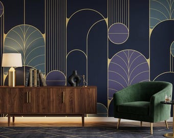 May include: An interior design scene featuring a dark blue wall with gold geometric patterns. A wooden cabinet with a gold lamp and books sits below the wall. A green velvet armchair and a small side table complete the room's decor.