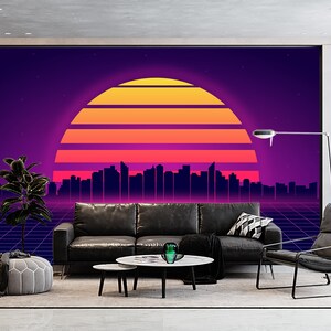 May include: A modern living room with a large wall mural featuring a retro sunset design in shades of orange, pink, and purple. The room includes a black leather sofa, a gray ottoman, and a black armchair. A coffee table and a floor lamp complete the scene.