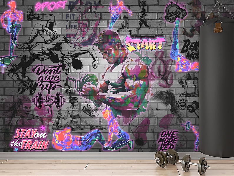 K&ouml;nnte beinhalten: Eine Backsteinwand mit einem bunten Graffiti-Wandbild, das verschiedene Fitnessaktivit&auml;ten darstellt. Das Wandbild zeigt Bilder von Menschen, die trainieren, Gewichte heben und boxen. Der Text "Don't give up", "Stay on the train", "Start" und "One more rep" ist in das Wandbild integriert. Im Vordergrund liegen zwei schwarze Hanteln auf dem Boden.