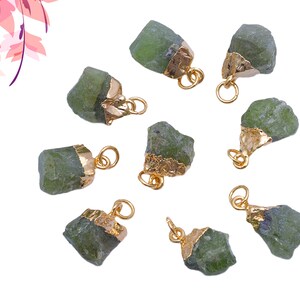 Op de afbeelding: Tien groene edelsteen hangers met gouden accenten. De edelstenen zijn ruw en hebben een natuurlijke, onbewerkte uitstraling. De hangers zijn perfect voor het maken van sieraden of knutselen.