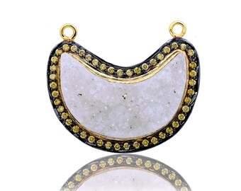 May include: A crescent-shaped pendant with a white, textured stone set in a black and gold frame. The frame is decorated with small, yellow gemstones.