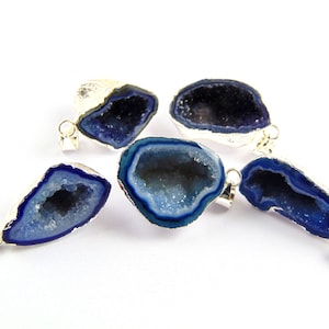 May include: Five blue agate crystal pendants with silver settings. The crystals are all different shapes and sizes, and they have a natural, rough texture.