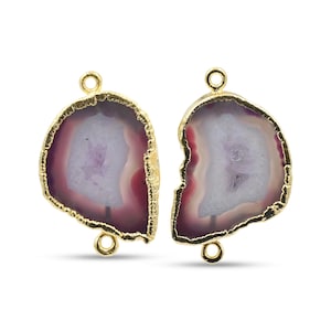 Könnte beinhalten: Zwei Edelsteinanhänger mit goldfarbenem Rand. Die Anhänger haben eine halbkreisförmige Form mit einer goldfarbenen Schlaufe oben und unten. Der Edelstein hat eine weiße Mitte, umgeben von einem hellvioletten und dunkelvioletten Rand.