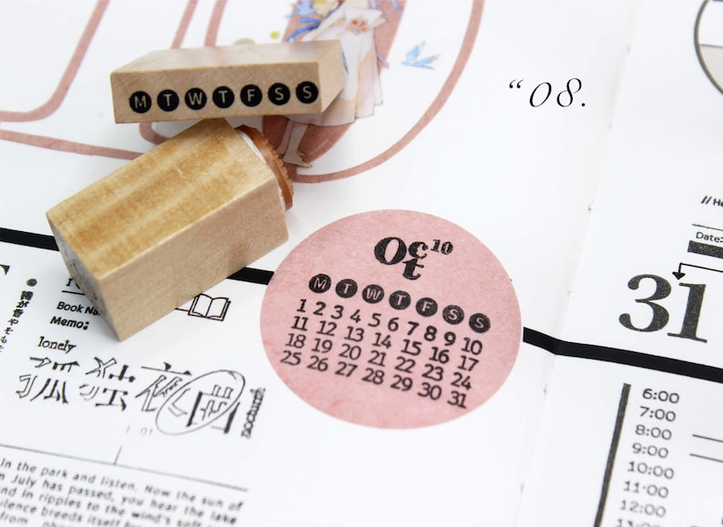 Puede incluir: Sellos de madera con los d&iacute;as de la semana y un calendario de octubre de 2010. El calendario est&aacute; en una pegatina circular rosa. Los sellos est&aacute;n en una p&aacute;gina con texto japon&eacute;s y el n&uacute;mero "08."