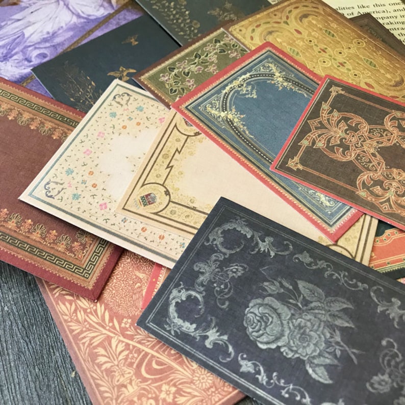 May include: A collection of decorative paper cards with ornate borders and designs. The cards are in various colors, including red, blue, green, and black. The cards are perfect for scrapbooking, card making, or other craft projects.